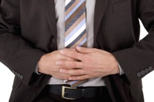 man with stomach pain holding his abdomen