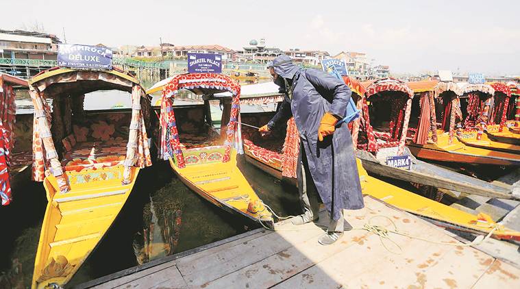 Man disinfects boats in Kashmir